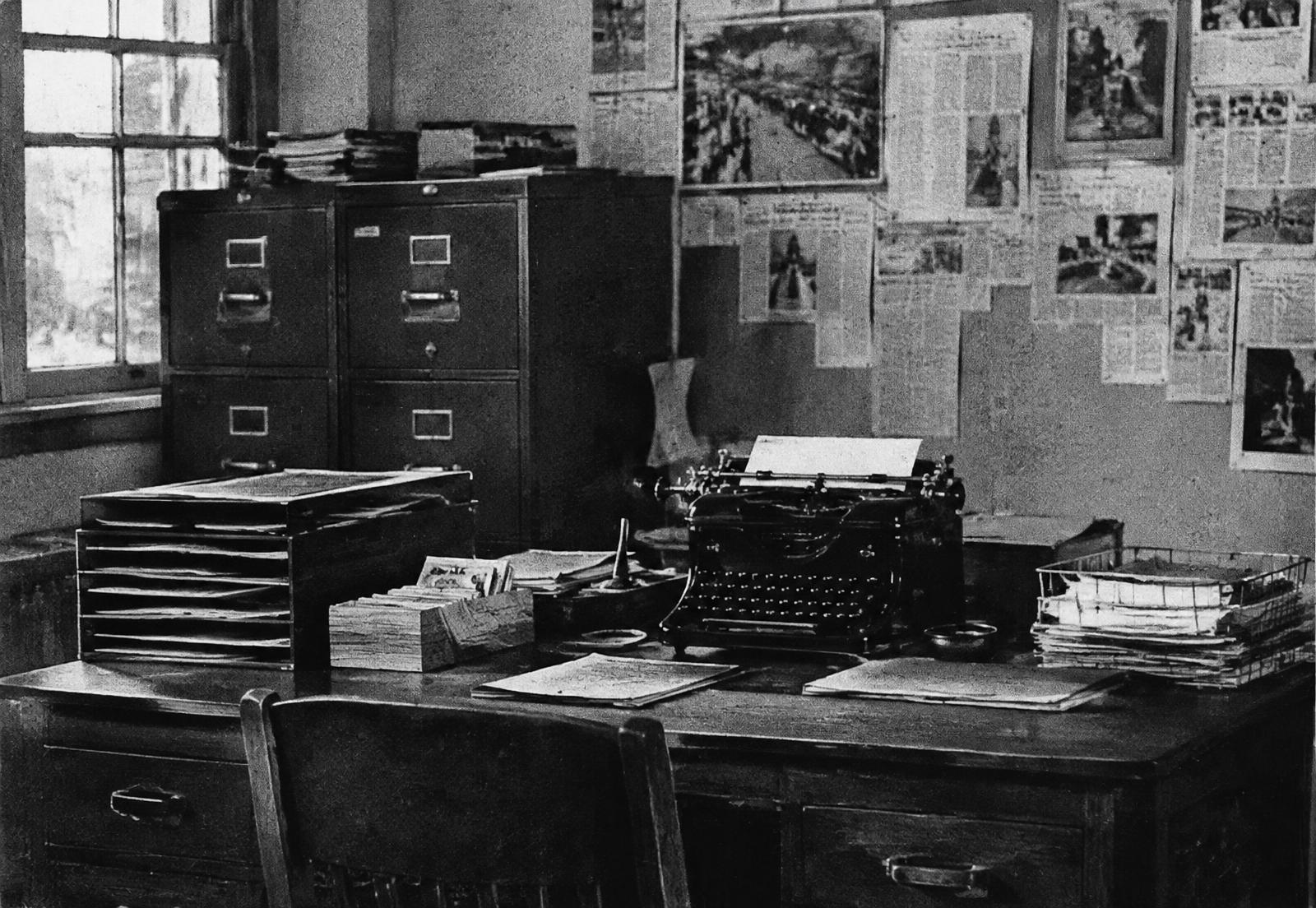 Archival-style newsroom desk with filing cabinets